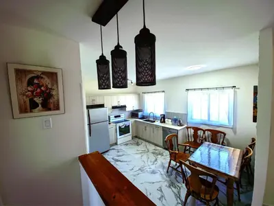 a kitchen with a table and chairs in it at Warm Welcome Home in Longueuil