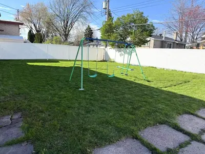 a playground with a swing set in a yard at Warm Welcome Home in Longueuil