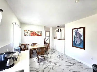 a kitchen and dining room with marble flooring at Warm Welcome Home in Longueuil