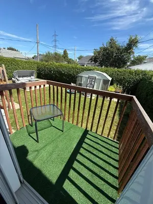 a deck with a bench and a chair on it at Apartment 3 chambres near Montréal in Sainte-Catherine