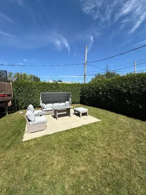 a patio with two couches and a table and a bench at Apartment 3 chambres near Montréal in Sainte-Catherine