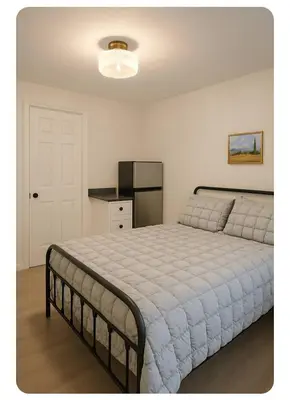 a bedroom with a large bed and a kitchen at La Victorienne in Louiseville