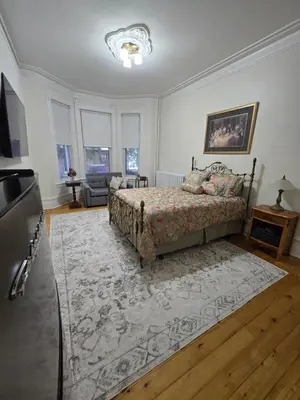 a bedroom with a bed and a rug at La Victorienne in Louiseville