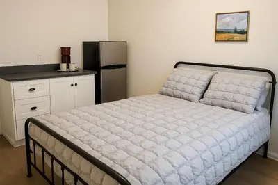 a bed in a room with a refrigerator in a kitchen at La Victorienne in Louiseville