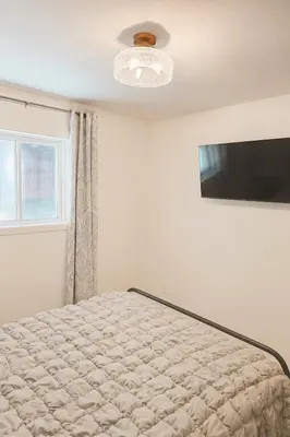a bedroom with a bed and a television at La Victorienne in Louiseville