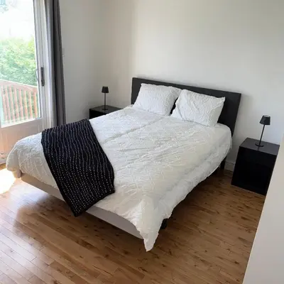a bedroom with a large bed with white sheets and pillows at Chambre à louer proche de Montréal in Sainte-Catherine