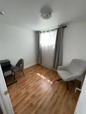 a living room with a desk and a chair at Chambre à louer proche de Montréal in Sainte-Catherine