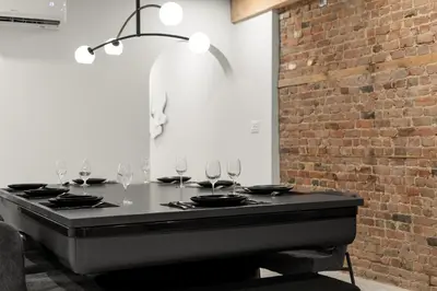 a table with wine glasses on it with a brick wall at SD5 Harmony sur le plateau in Montréal