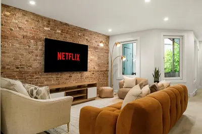 a living room with a couch and a tv on a brick wall at SD5 Harmony sur le plateau in Montréal