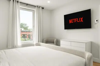 a bedroom with a bed and a tv on the wall at SD5 Harmony sur le plateau in Montréal