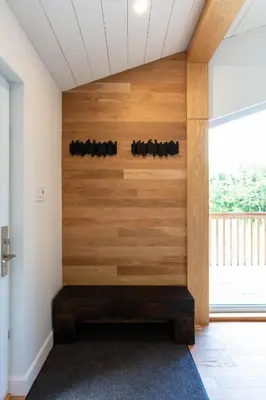 a room with a wooden wall with a bench at By the river - Le 91 in Frelighsburg