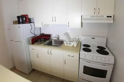 a small kitchen with a sink and a white refrigerator at Studio, balcony, pool view, sauna in Montréal