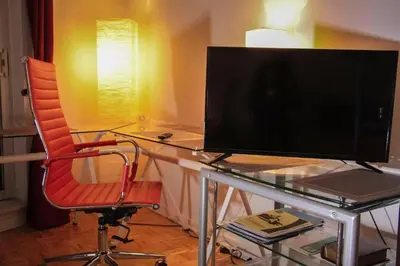 a computer monitor sitting on a glass desk with a chair at Studio, balcony, pool view, sauna in Montréal