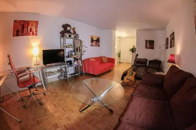 a living room with a red couch and a glass table at Studio, balcony, pool view, sauna in Montréal