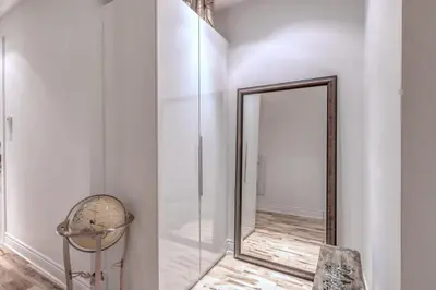 a mirror in a white room with a chair at Old Port Elegance and Designer Loft with PV Terrace in Montréal