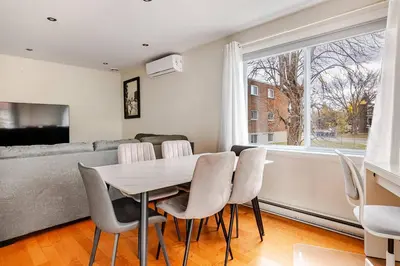 a dining room with a table and chairs and a couch at Voltaire 2 Appartement 4,5 , 2ch Laval, Canada meublé in Laval