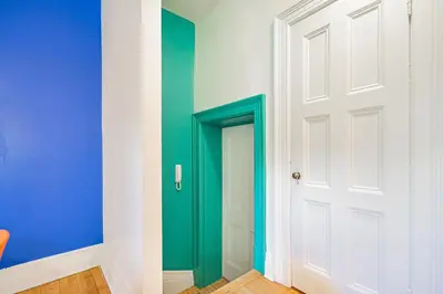 a green door in a room with a blue wall at Unique Downtown Montreal Stay with Private Terrace in Montréal