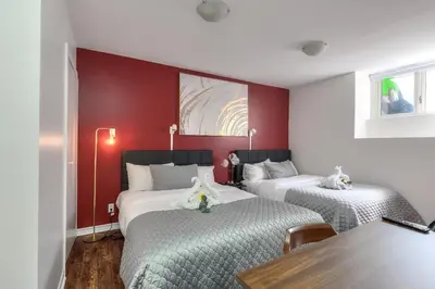 two beds in a room with red walls at Fox Aparthotel - Palais Des Congres in Montréal