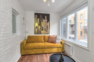 a living room with a yellow couch and a window at Fox Aparthotel Palais Des Congres V in Montréal