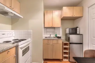 a kitchen with white appliances and wooden cabinets at Fox Aparthotel Palais Des Congres V in Montréal