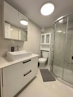 a white bathroom with a sink and a shower at Modern Studio-Patio & BBQ-Parking Included in Montréal