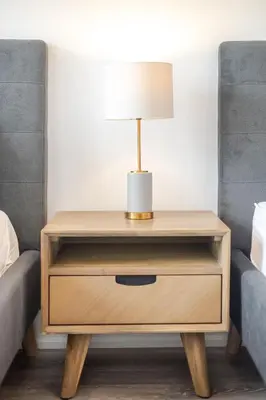 a nightstand with a lamp on it next to two beds at Theatre Hotel by Lodgo in Montréal