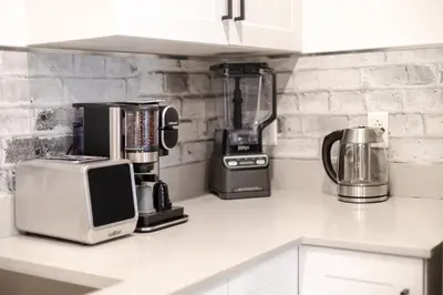 a kitchen counter with a coffee maker and a blender at Theatre Hotel by Lodgo in Montréal