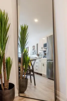 a mirror in a kitchen with a table and some plants at Theatre Hotel by Lodgo in Montréal