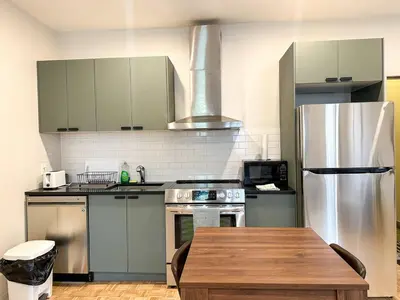 a kitchen with stainless steel appliances and a wooden table at Lovely One-Bedroom in Vibrant Plateau Mont-Royal in Montréal