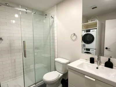 a bathroom with a toilet and a sink and a shower at Lovely One-Bedroom in Vibrant Plateau Mont-Royal in Montréal