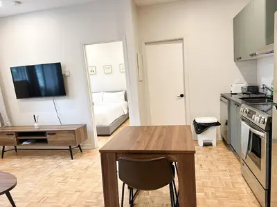 a kitchen and living room with a table and a couch at Lovely One-Bedroom in Vibrant Plateau Mont-Royal in Montréal