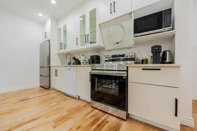 a kitchen with white cabinets and stainless steel appliances at Newly Renovated 3BR 2BA Spacious and Modern in Montréal