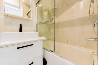 a bathroom with a sink and a shower at Newly Renovated 3BR 2BA Spacious and Modern in Montréal