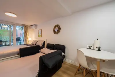 a bedroom with a couch and a bed and a table at Renovated Studio w Parking Queen Bed and Sofa Bed in Montréal
