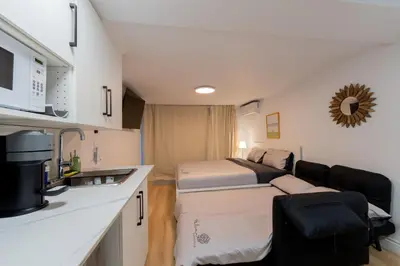 a small room with a bed and a kitchen at Renovated Studio w Parking Queen Bed and Sofa Bed in Montréal