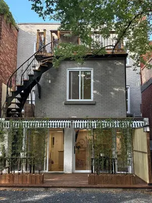 a house with a staircase on the side of it at Renovated Studio w Parking Queen Bed and Sofa Bed in Montréal