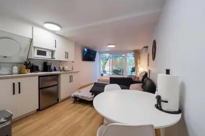 a kitchen and a living room with a white table in a room at Renovated Studio w Parking Queen Bed and Sofa Bed in Montréal