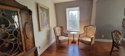 a room with two chairs and a table and a window at Manoir Hunting 1869 in Waterville