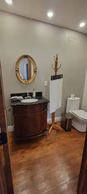 a bathroom with a sink and a mirror and a toilet at Manoir Hunting 1869 in Waterville