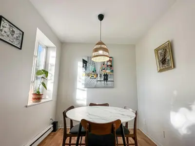 a dining room with a white table and chairs at Chic & Fully Furnished 2-Bedroom Apartment in Prestigious Westmount in Montréal