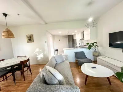 a living room with a couch and a table at Chic & Fully Furnished 2-Bedroom Apartment in Prestigious Westmount in Montréal