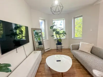 a living room with a couch and a table at Chic & Fully Furnished 2-Bedroom Apartment in Prestigious Westmount in Montréal