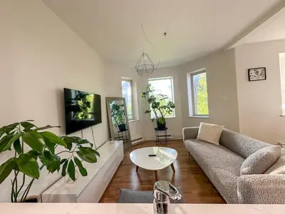 a living room with a couch and a table at Chic & Fully Furnished 2-Bedroom Apartment in Prestigious Westmount in Montréal