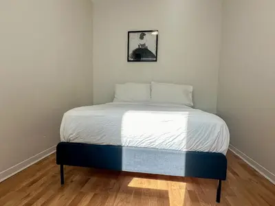 a bed in a corner of a room at Chic & Fully Furnished 2-Bedroom Apartment in Prestigious Westmount in Montréal