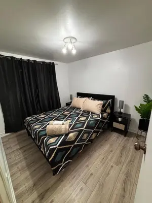 a bedroom with a bed with black curtains at Studio, Near Montreal in Repentigny