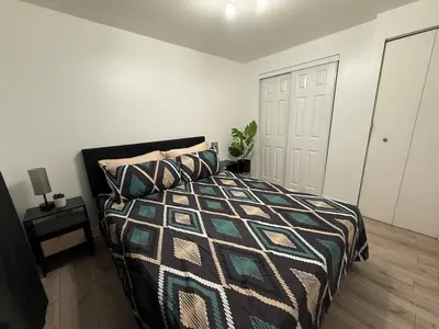 a bedroom with a bed and a white wall at Studio, Near Montreal in Repentigny
