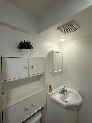 a white bathroom with a sink and a toilet at Studio, Near Montreal in Repentigny