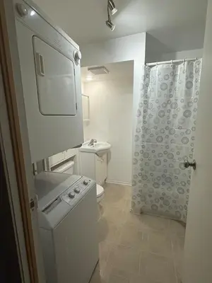 a white bathroom with a toilet and a sink at Studio, Near Montreal in Repentigny
