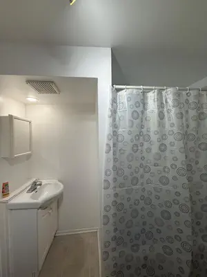 a bathroom with a shower curtain and a sink at Studio, Near Montreal in Repentigny