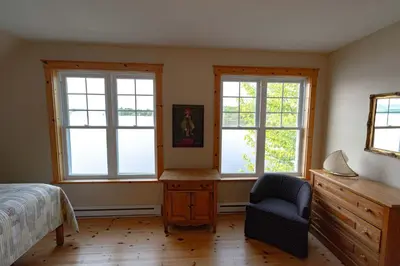 a bedroom with two windows and a desk and a chair at Mirror Lakefront and SPA - A Fleur D'eau in Dudswell